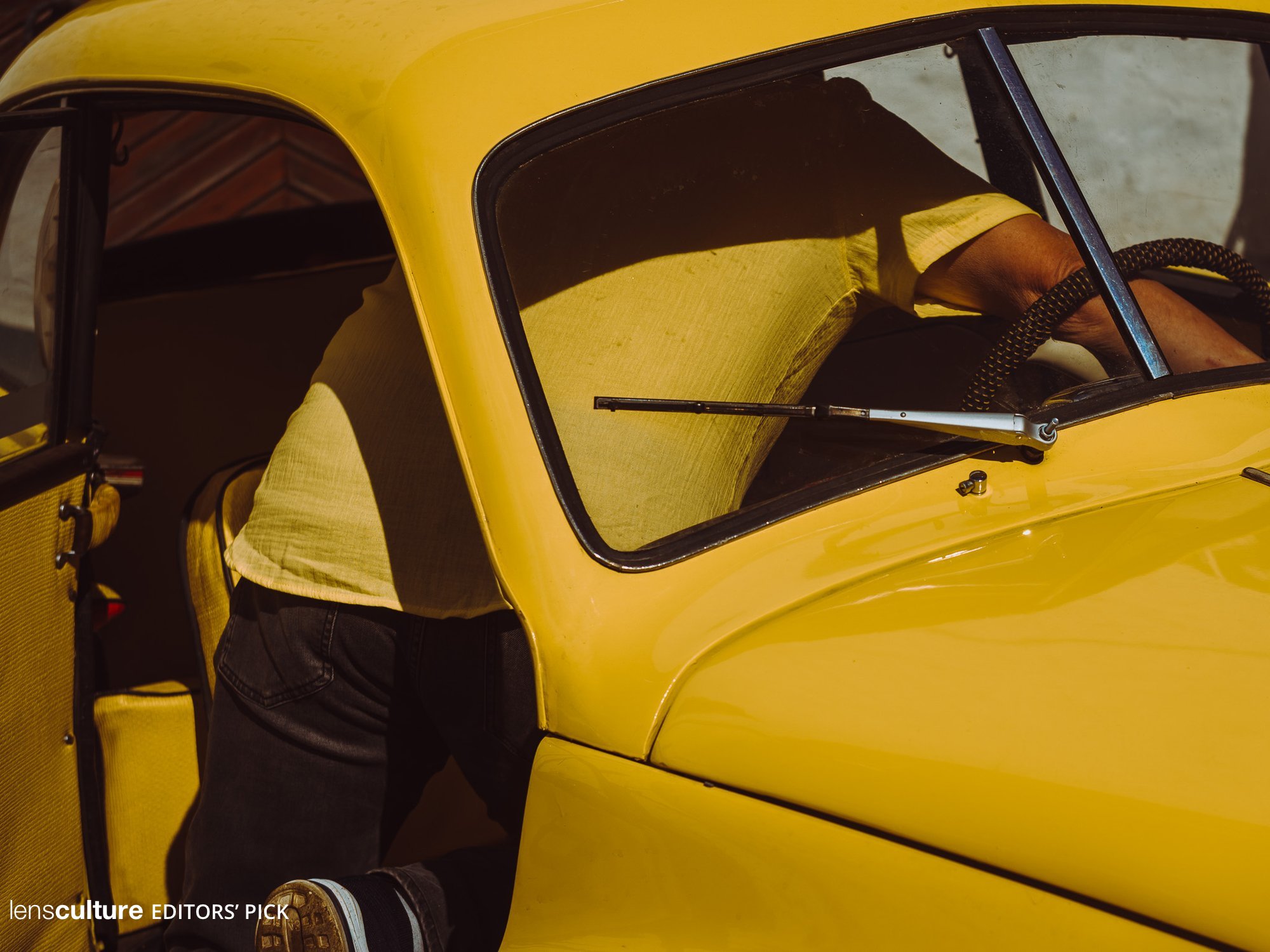 A man in a yellow T-shirt in a yellow car