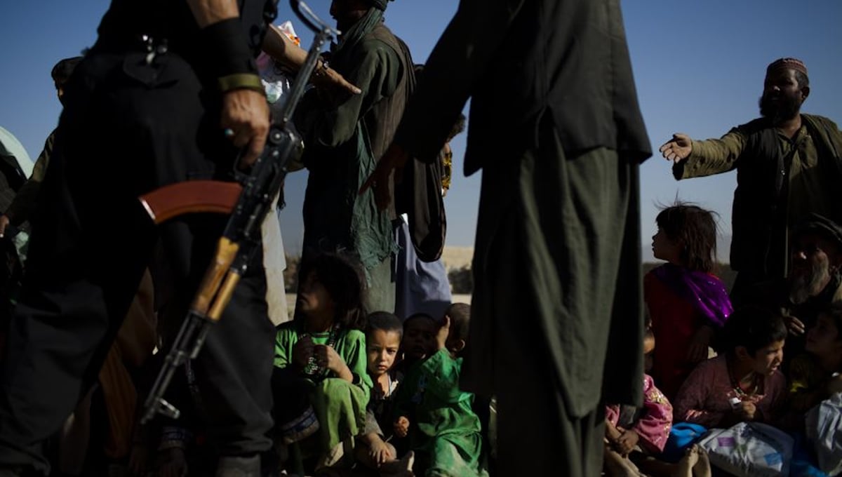 Children wait to receive the first loaves of bread from an Afghani-American woman handing out food and clothing at an Internally Displaced Persons (IDP) camp, called Charhi Qhambar, on the edge of Kabul. Most of the IDPs here are from Kandahar and Helmand provinces. Most families have lost at least one family member from American bombs. © Michael Christopher Brown