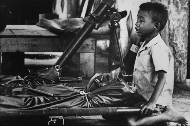 Cambodia. Child crying over his father. 1974. From the book "War Photographer: Between Shadow and Light" © Christine Spengler