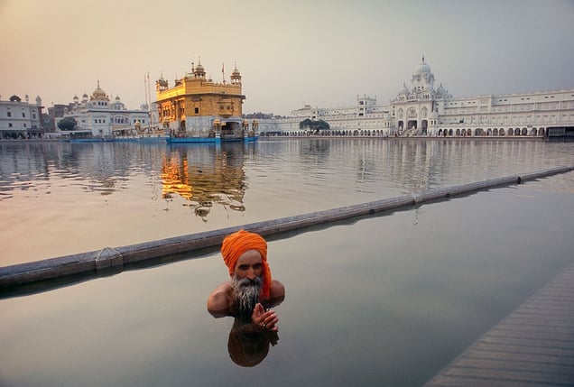 Amritsar, India: A pilgrim during his ritual washing in lake Sarovar, in the centre of which stands the famous Sikh temple Hari Mandir, The golden temple. © Matjaz Krivic