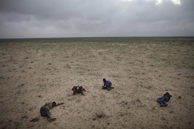 1st Prize Contemporary Issues Stories  © Ed Ou, Canada, Reportage by Getty Images. Escape from Somalia, March: Four Somali refugees en route to Yemen sleep in the desert after traveling all night on muddy roads and in pouring rain, Somaliland, 15 March.