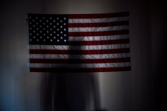 Manny Bojorquez casts a shadow on a flag in his apartment in Mesa, Arizona. He was a member of the 2/7 Marines, which fought in Afghanistan in 2008 and now has a suicide rate more than 10 times higher than the national average.
