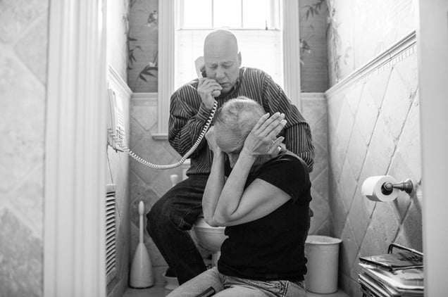 Howie and Laurel Borowick sit next to the bathroom telephone as they hear the most recent news from their oncologist- good scans for both of them, and their respective tumors are shrinking. Chappaqua, New York. March 2013 © Nancy Borowick