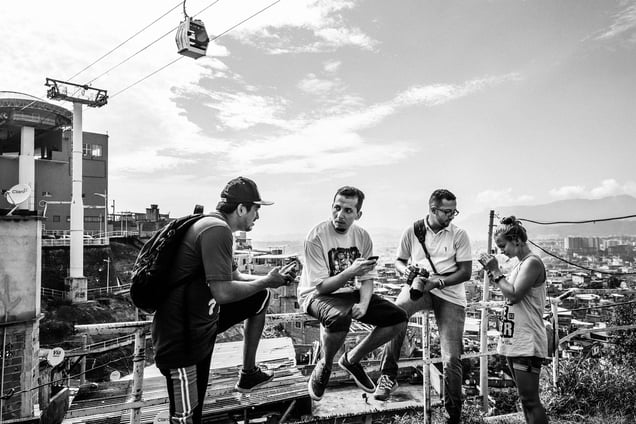 Papo Reto collective members at Complexo do Alemao with a cableway station and cab in their back; Rio de Janeiro, Brazil, 08 February 2015.