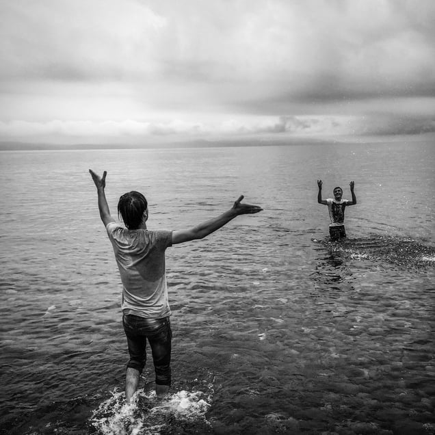 Afghan refugees celebrate after landing in Lesbos, Greece by boat from Turkey.