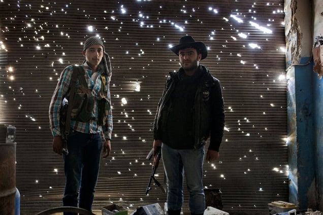 Two YPG fighters stand in a damaged garage in the Sheikh Maqsood District of Aleppo, Syria on April 20, 2013. The YPG (Popular Protection Units) of the Kurdish Democratic Union Party (PYD)  considers itself a popular democratic militia with the mission of maintaining order and protecting the lives of those in the primarily kurdish districts of Syria. In March 2013 YPG and FSA began to cooperate.