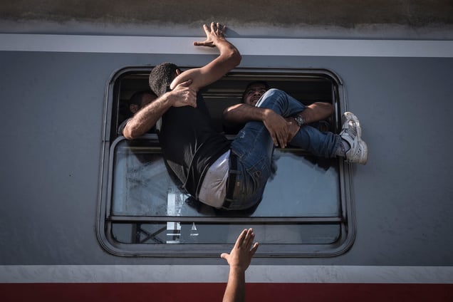 Refugees attempt to board a train headed to Zagreb, Croatia in Tovarnik, Hungary, 18 September 2015.