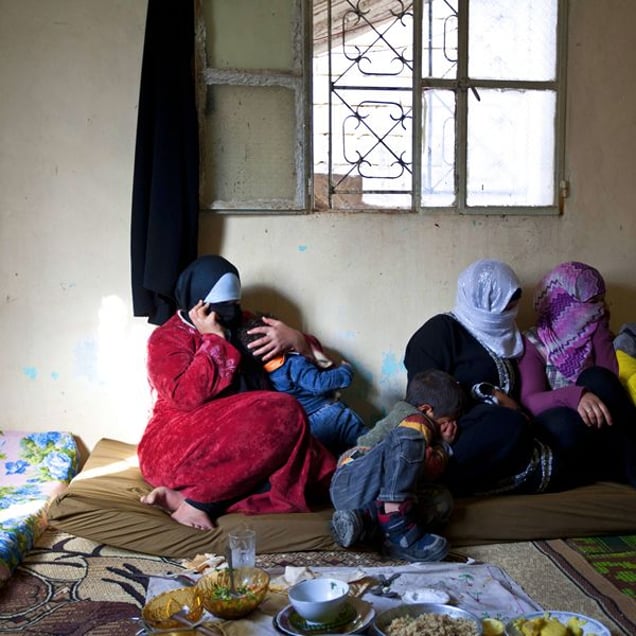Jdeideh, Lebanon. Tara, 25 years old (on the left holding her son), escaped from Baba Amro, Homs where she was living with ther husband and two kids. She left Syria after they had destroyed her house and her husband stayed there to help his father. She has no news since she left and is still hoping to hear from him. Unfortunately, her family knows that he got killed. © Matilde Gattoni