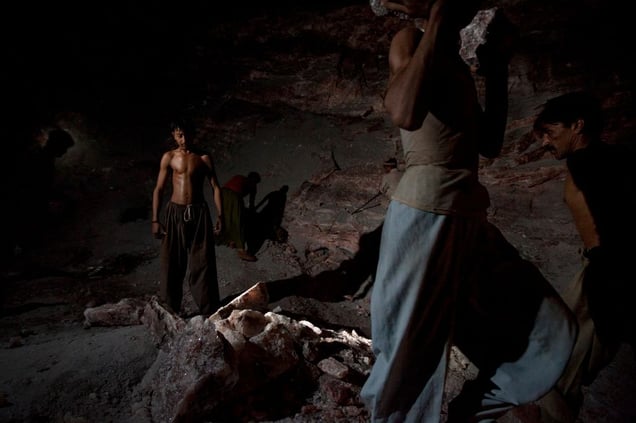 Salt miners load a truck with rock salt after having exploded the mine wall with dynamite at the Khewra salt mine.
