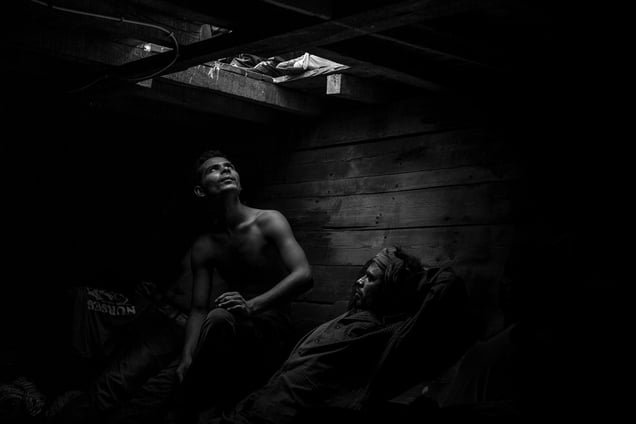 Bangladeshi and Pakistani migrants wait to be evacuated from the fetid  hold of a smuggler boat off the coast of Libya