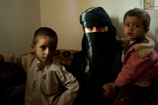 The wife of Abdul Latif mourns in her home with family after her husband was killed in a Saudi-led coalition airstrike, July 7, 2015.  Abdul Latif, a 35 year old farmer and father of seven, was selling fruit and vegetables on the side of the road when the airstrike hit the side of the road. It killed Abdul Latif and nine young boys from Al Joob. © Alex Potter