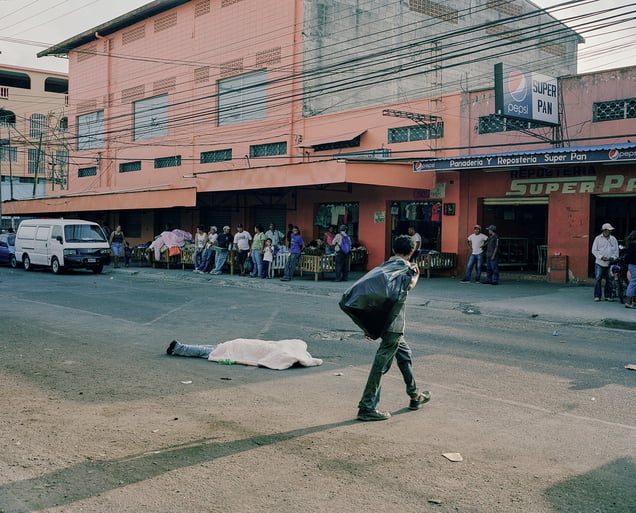 Merchants in San Pedro Sula, go about their business while a body lies in the middle of the street. Dead bodies sit for hours before the coroner has time to pick them up. © Dominic Bracco II / PRIME