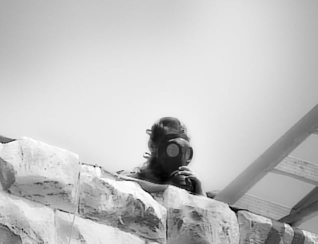 Former Israeli settlement of Sanur, West Bank, now Palestinian Authority (2005). A child-settler, wearing a gas mask, looks down from the besieged fortress as Israeli policemen prepare for the final assault to evict him and his other hundred and some companions.