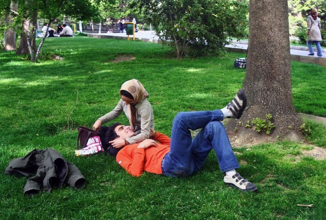 Young couple shares an intimate moment in a park in central Tehran. In the past, public displays of affection would have been severely punished. Today, couples can walk freely in parks and sit together. While holding hands is tolerated, other affectionate public displays are not permitted by the regime and are considered taboo for unmarried women. Tehran, IRAN - June 2008
© Copyright 1979-2009 Alfred Yaghobzadeh. All rights reserved.