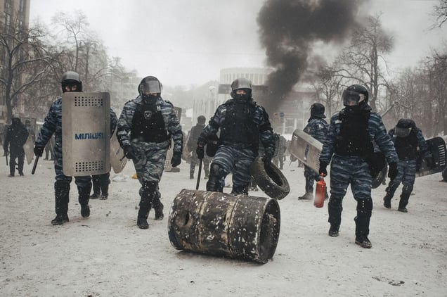 Riot police barrel the roll and carry tires, which they took away from protesters during the attack in the center of Kiev on Jan. 22, 2014.