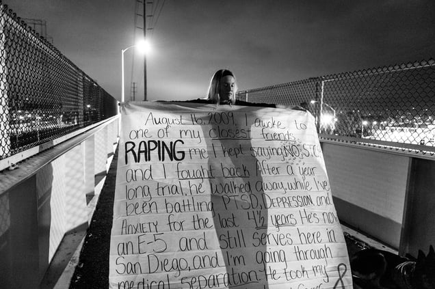 US Navy sailor Melissa Bania holds a banner inscribed with the story of her rape before hanging it on the footbridge across from Naval Station San Diego. Military Sexual Trauma survivors gathered in San Diego to bring attention to the epidemic of rape in America’s military, 21 April 2014.