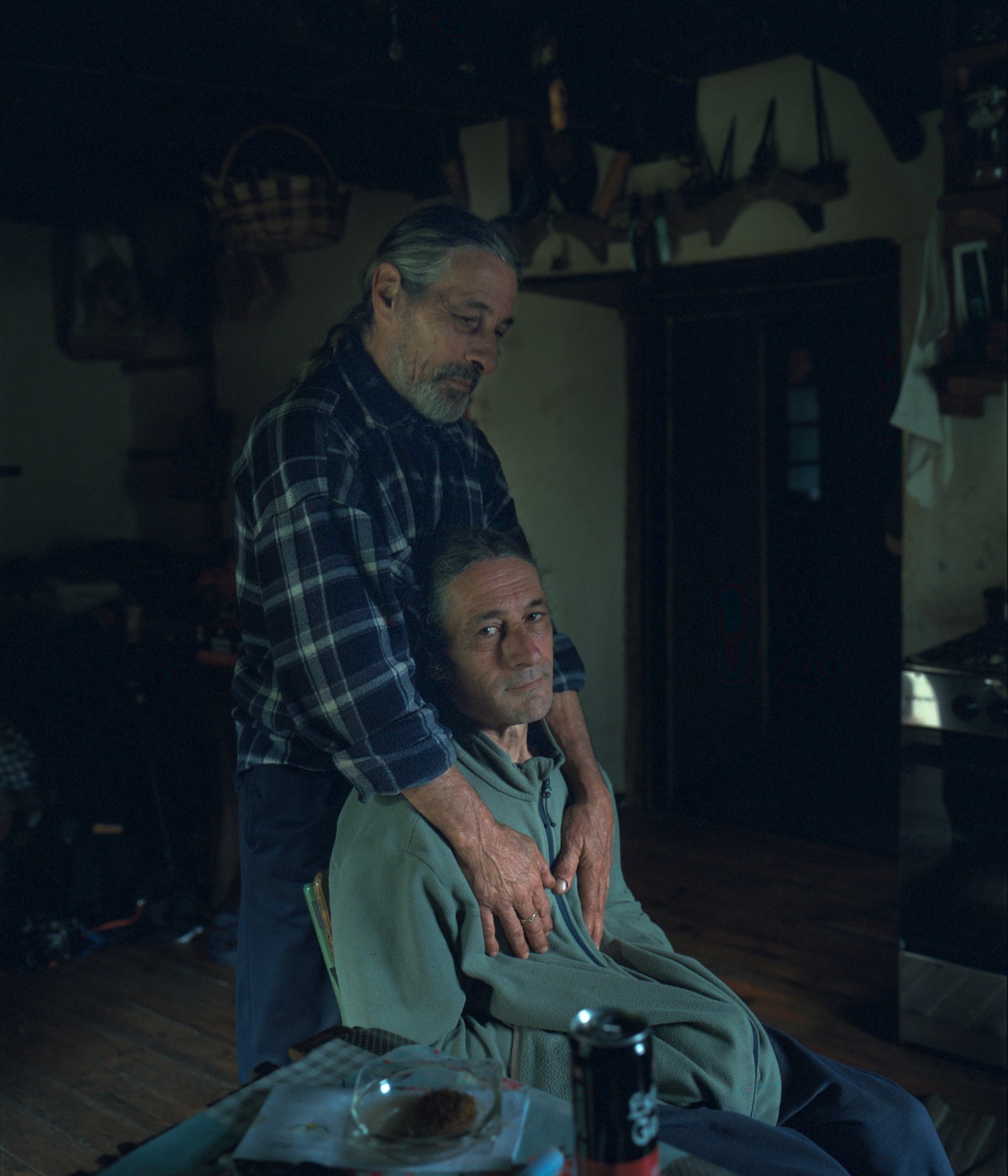 Adolf & Raul. Adolf and Raul came from Barcelona to live in a house in Barcela, an abandoned village in the Galician forest, at the foot of the Grandas de Salime reservoir. Locals accused them of intending to live there to gain economic benefits from the communal land, sparking significant disputes between them and the neighbors. One night, some neighbors attempted to set fire to Adolfo and Raúl's house while they were inside. To this day, Adolfo and Raúl are marginalized from the rest of the village, and they have spent almost 5 years without practically leaving their home. © Carlos Folgoso Sueiro