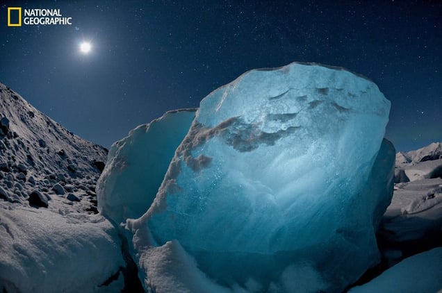 Destined to melt, an 800-pound chunk of ice glowed in the moonlight. It washed up in a lagoon created by a receding glacier, part of a worldwide shrinkage of glacial ice. From the October 125th anniversary issue of National Geographic magazine © James Balog/National Geographic