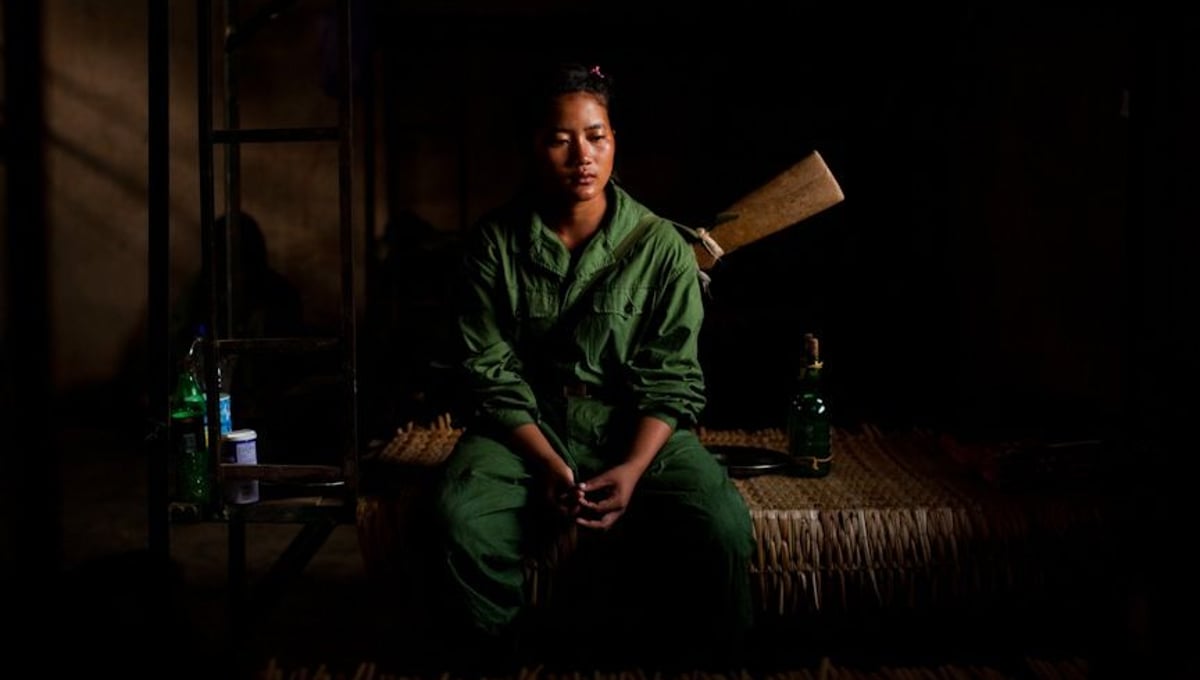 Tears roll down a young woman’s face as she sits on her bed just after morning military training at the Kachin Independence Army's (KIA) 5th brigade headquarters outside of Laiza, Kachin State, Myanmar, May 21, 2013. For most of the women going through military training, this was their first experience away from their home and family. © Adriane Ohanesian