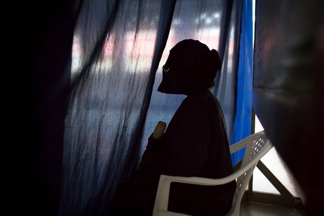 A veiled rape survivor testified in court behind a curtain to further shield her from the eyes of those she accused. Special care is taken to provide rape survivors with disguises, curtains, veils, whatever they may need to feel secure when giving their testimony. The women are referred to by numbers instead of by name to maintain their anonymity. © Diana Zeyneb Alhindawi