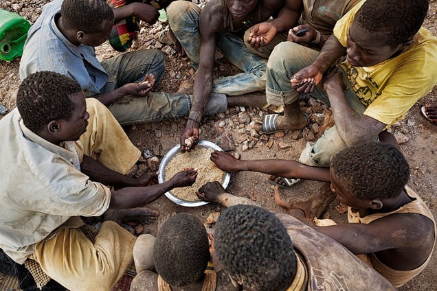 At midday, the miners gather for lunch, usually its a bowl of rice with some oil and a bit of fish, eaten by hand from a communal cooking pot. © Matjaz Krivic