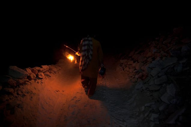 A salt miner leaves the Kalabagh salt mine using only the light from his oil lantern.