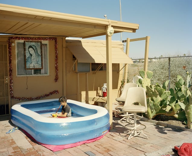 Alexis. Alexis playing in an inflatable pool outside of his family's trailer home along the shores of the Salton Sea. The Salton Sea, once a prosperous lake from the run-off of agricultural water, is now a toxic wasteland due to drought. The lithium mines are now located just a few short miles from these shores. Desert Shores, CA. 2022. © Scott Rossi
