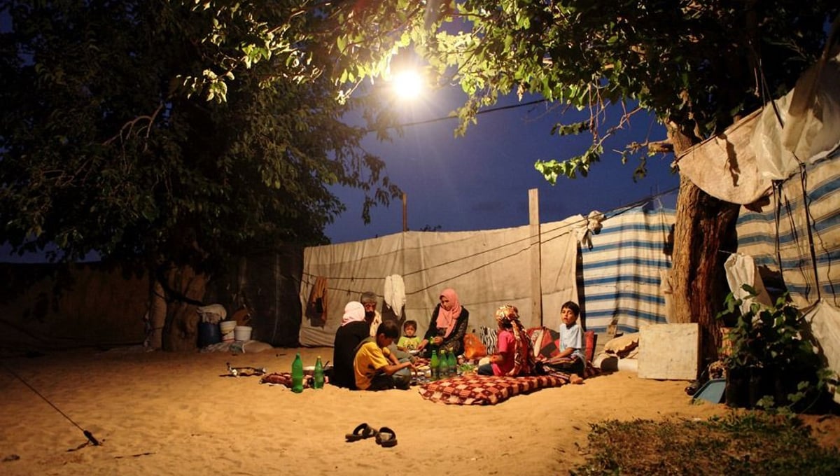 A Palestinian family which lost its home in the 2009 Israeli attack on the Gaza Strip, sitting outside their make-shift shelter, Gaza 2009.