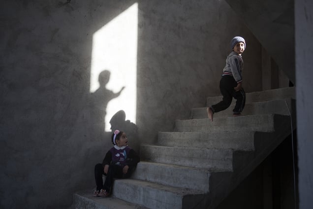 Children play on an unfinished staircase inside the building where they have been living with their families since August 2014, when they escaped from Sinjar. 01/02/15. Sitak, Iraq.