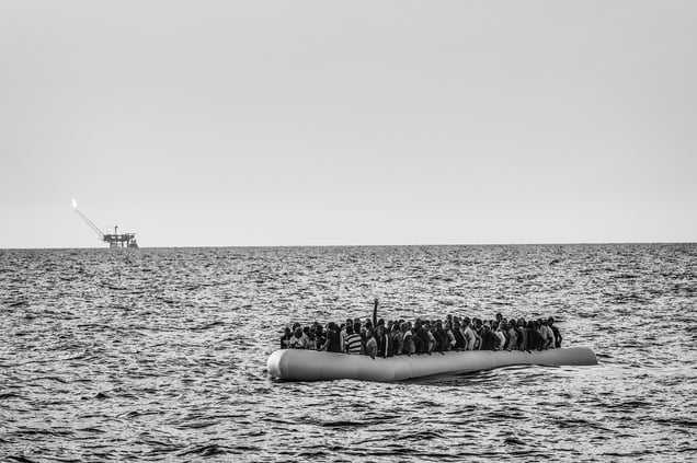 An overcrowded rubber dinghy sailing from Libya to Italy, Strait of Sicily,Mediterranean Sea, 26 August 2015.