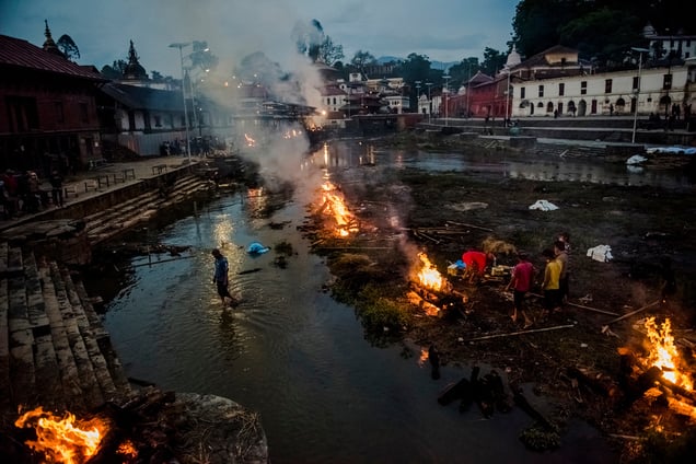 Flames rise from burning funeral pyres during the cremation of earthquake victims at the Pashupatinath Temple on the banks of Bagmati River, Kathmandu,Nepal, 28 April 2015.