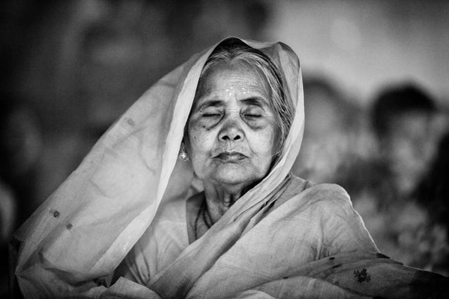 An old Hindu woman sits with lights (Prodip) and prays to God in front of Shri Shri Lokanath Brahmachar Ashram temple during the Rakher Upobash at Barodi, Narayangonj © Suvra Kanti Das, Bangladesh. Shortlist, Arts & Culture, Professional Competition. 2014 Sony World Photography Awards