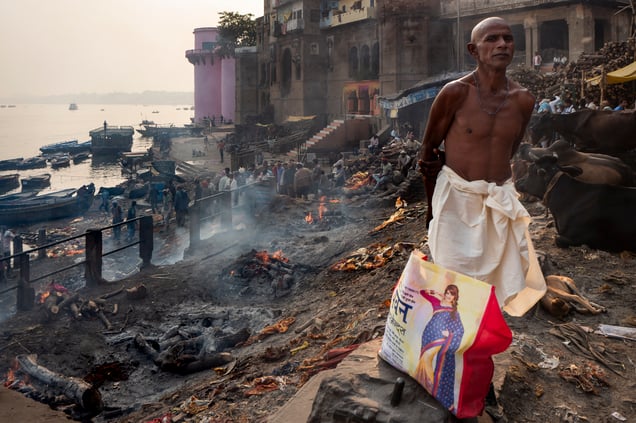 Dressed in white and with his head shaved as a sign of grief, a man waits  for his relative to be cremated. Mnaikarnika is the main Burning Ghat in Varanasi