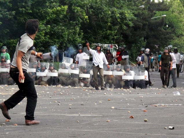Iranian opposition protester throwing stones at armed Basij members during  a demonstration in Tehran. Thousands of Iranians clashed with police as they defied an ultimatum from supreme leader Ayatollah Ali Khamenei for an end to protests over last weeks disputed presidential election Tehran. IRAN - June 20, 2009
© Copyright 1979-2009 Alfred Yaghobzadeh. All rights reserved.
