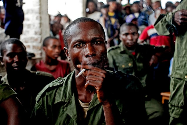 Sido Bizinungu, a close associate of Lt. Col Kebibi Mutware, smokes a cigarette after being convicted of crimes against humanity in the town of Baraka, Democratic Republic of Congo on Monday, Feb. 21, 2011.