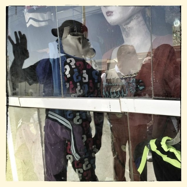 Reflection of photographer Michael Christopher Brown in a shop window in Za'atari refugee camp.