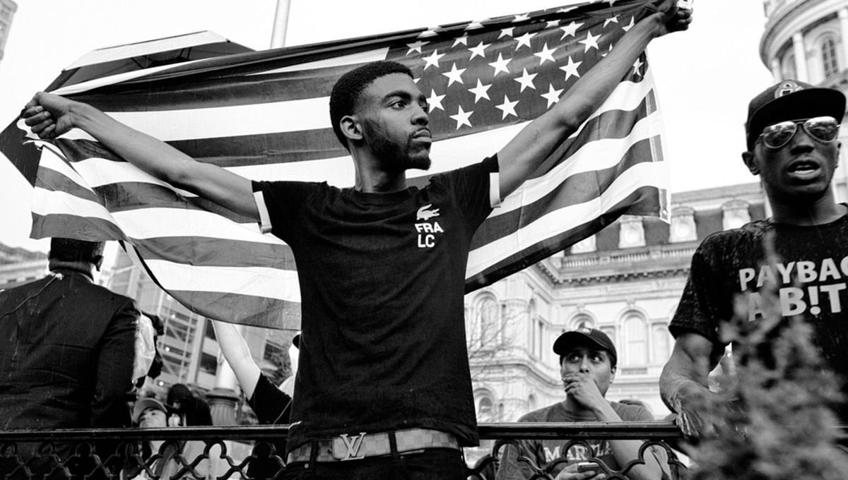 Baltimore, Md- A young protester holding the American Flag during the March For Peace.