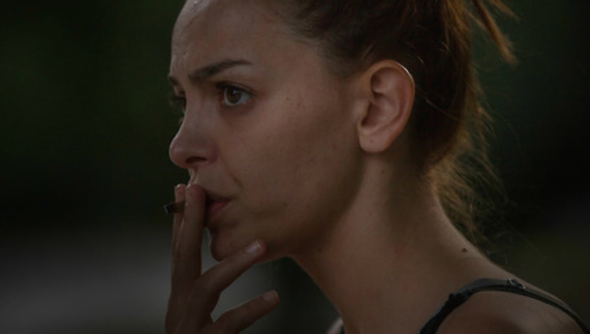 Angela contemplates her future and the challenges ahead, sitting in a park in Milan.