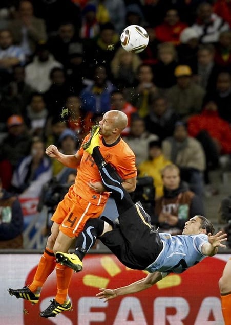 1st Prize Sport Single © Mike Hutchings, South Africa, for Reuters. Netherlands Demy de Zeeuw is kicked in the face by Uruguays Martin Cáceres during World Cup semi-final, Cape Town, 6 July