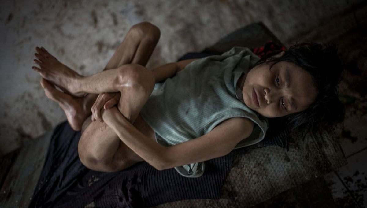 Indonesia, Bali, Singaraja - Kadek, 42, for years she stopped to talk. She has spent more than half her life in a room without windows. Kadek lies on a cot. Her family believes she is possessed by demons. The family refuses that Kadek gets treated with Western medicine. So far They have visited 57 ritual healer, but nothing worked. © Christian Werner