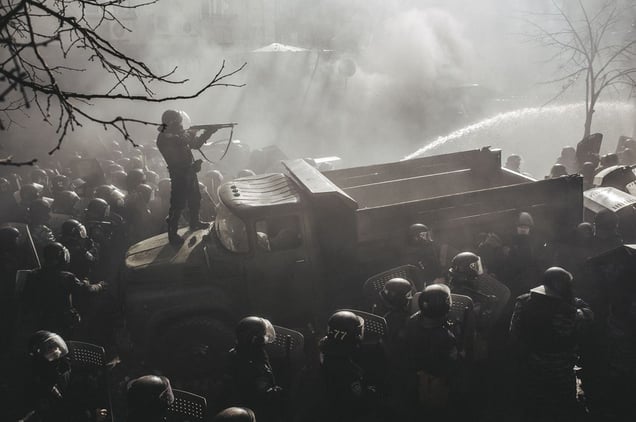 Riot policeman shot from pump gun standing on a burned truck during the confrontation on Shelkovichna street when protestors stormed Verhovna Rada (Ukrainian parliament). Kiev, Feb. 18, 2014
