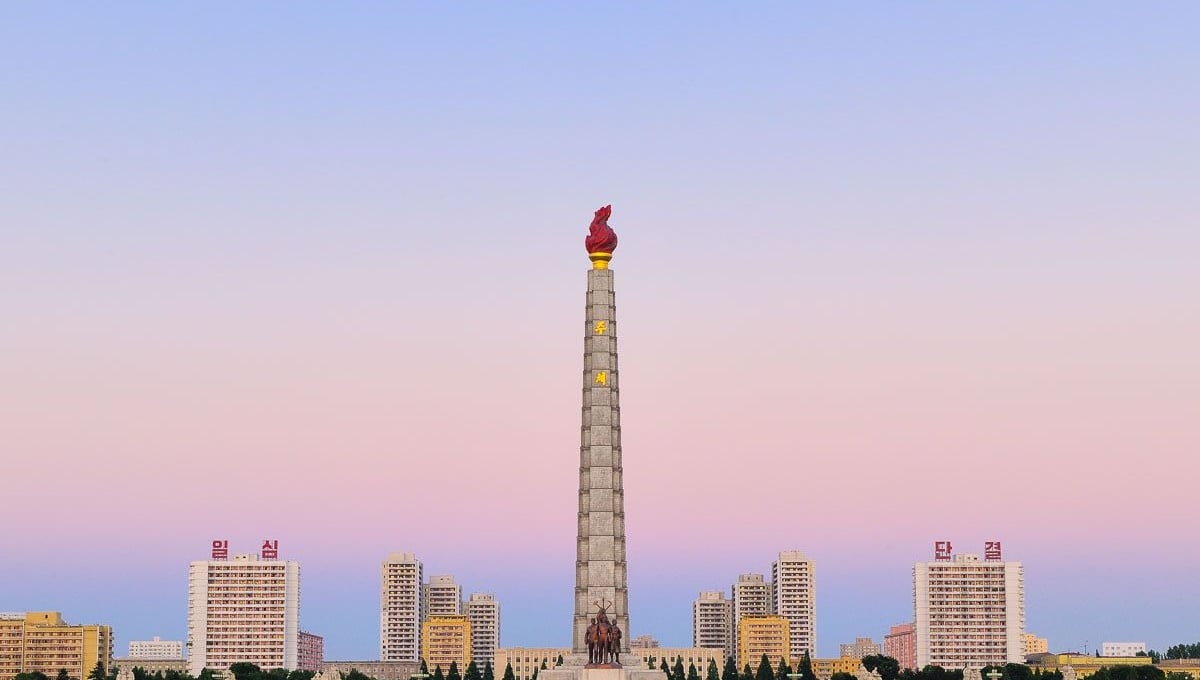 Juche Tower in the centre of Pyongyang surrounded by symmetrical, communist style architecture.