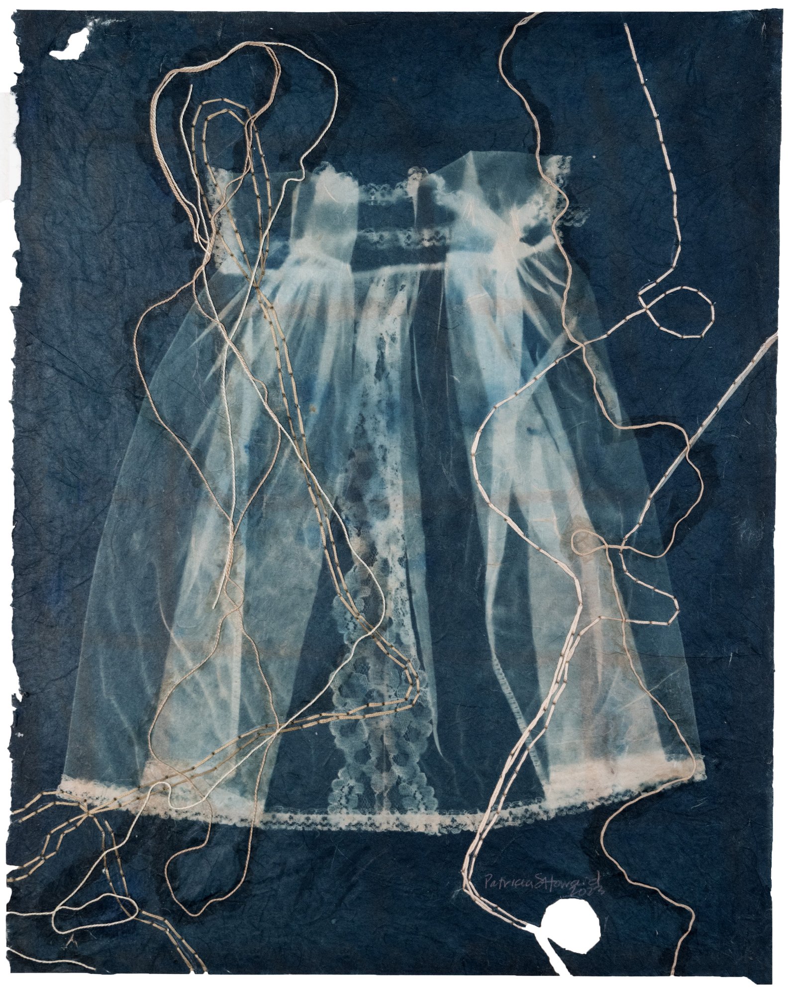 This is an image of a dress, made to resemble a christening gown, utilizing the cyanotype process onto semi-transparent, hand made paper. It has been toned with black tea and stitched with flax thread. the black tea tones the bright blue of the cyanotype to a brown and blue. The paper is ripped and torn in places and the edges of the paper are deckled. The cyanotype process was developed in the 1840s, the time period I am reflecting upon and flax thread was a textile product also found in Ireland as is black tea. The christening dress represents Catholicism, infants and lost lives. © Patricia Howard