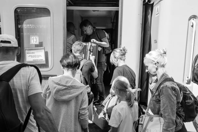 Holiday tourists are crowding at the entrance of the train returning from the seaside.