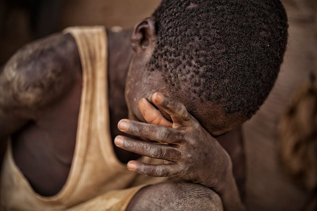 Nuru (13) cannot recall how long he has worked here. He has never been to school and does not know how to read or write. He is upset because his brother, who he works with, is angry at him for not processing enough material through a machine that they have to pay for daily. However, he quickly says that mining is still better than working on the fields back home. © Matjaz Krivic