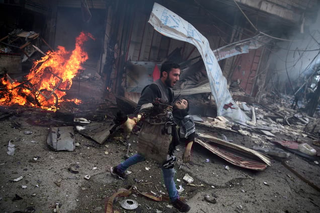 A Syrian man carries the body of a child, killed in an airstrike by government forces in Douma, Syria, 07 November 2015.