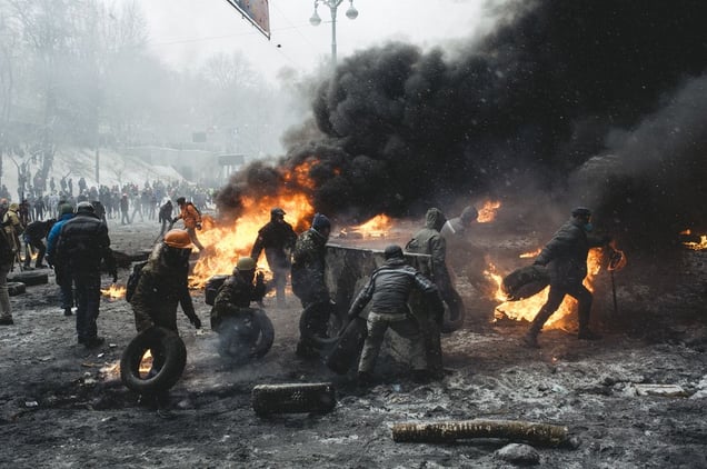 A protester carries a burning car ramp closer to the riot police cordon in the center of Kiev on Jan. 22, 2014.