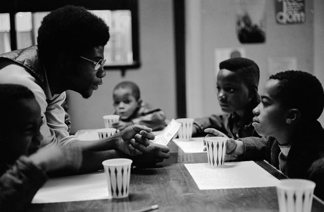 November, 1970 - Chicago, Illinois, USA: Free Breakfast Program.  Panther Jerry Dunigan, known as "Odinka", talks to kids while they eat breakfast on Chicago’s south side. The Free Breakfast for School Children Program was a community service program run by the Black Panther Party.