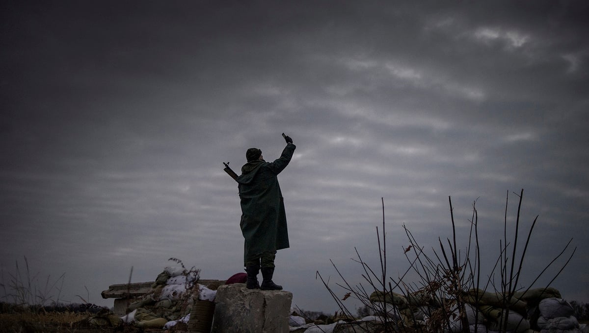 A rebel trying to catch a signal near the frontline