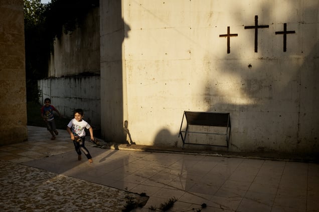 A displaced Christian boy from Qaraqosh inside the courtyard at Al Shuhada church. Around 800 Christian families have arrived to Shaqlawa since August 2014. Most of them have now been moved to shipping containers in a new camp in Erbil. 20/05/15. Shaqlawa, Iraq.